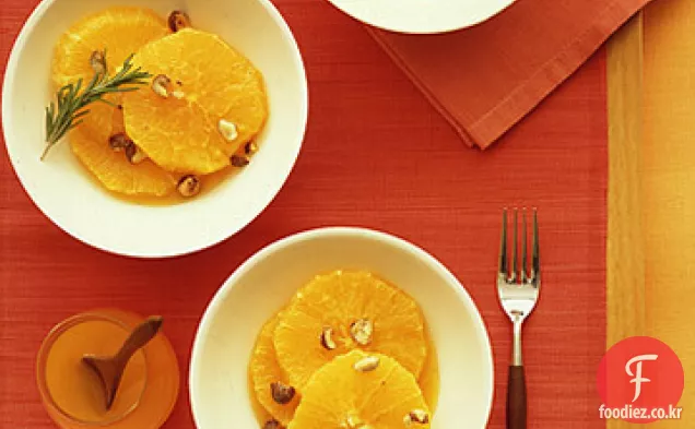 오렌지 꽃 시럽과 설탕에 절인 헤이즐넛을 곁들인 슬라이스 오렌지