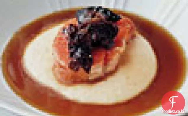 파르 메산 폴렌타와 버섯 콩솜으로 간신히 조리 된 연어.