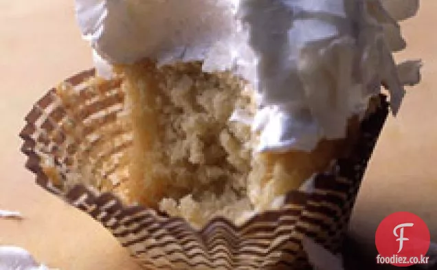7 분 프로스팅과 코코넛 플레이크를 곁들인 코코넛 컵 케이크