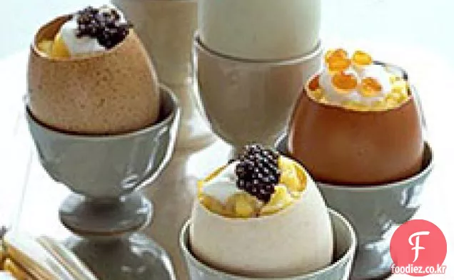 달걀 껍질 컵에 크림 프레이 체와 캐비어를 곁들인 스크램블 에그